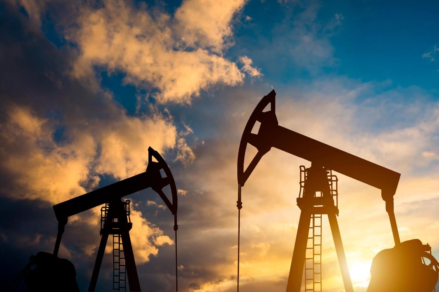 Oil pump at sunset against an industrial sky